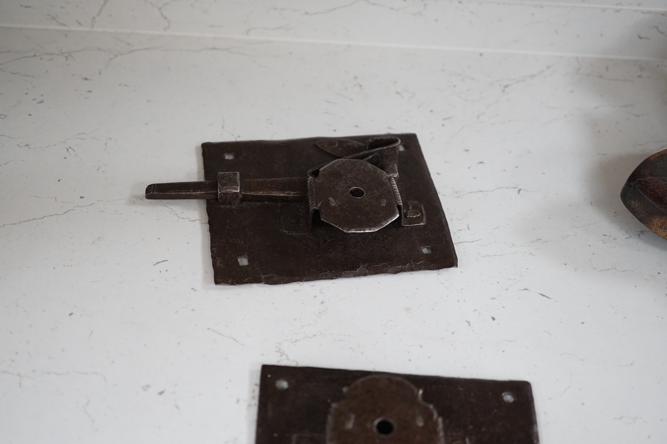 Three early ironwork lock plates with keys and a carved hardwood bolting lock